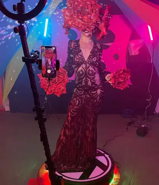 Plataforma 360 giratoria en un evento nocturno, con aro de luz y LED de la base encendidos mientras graba a una artista